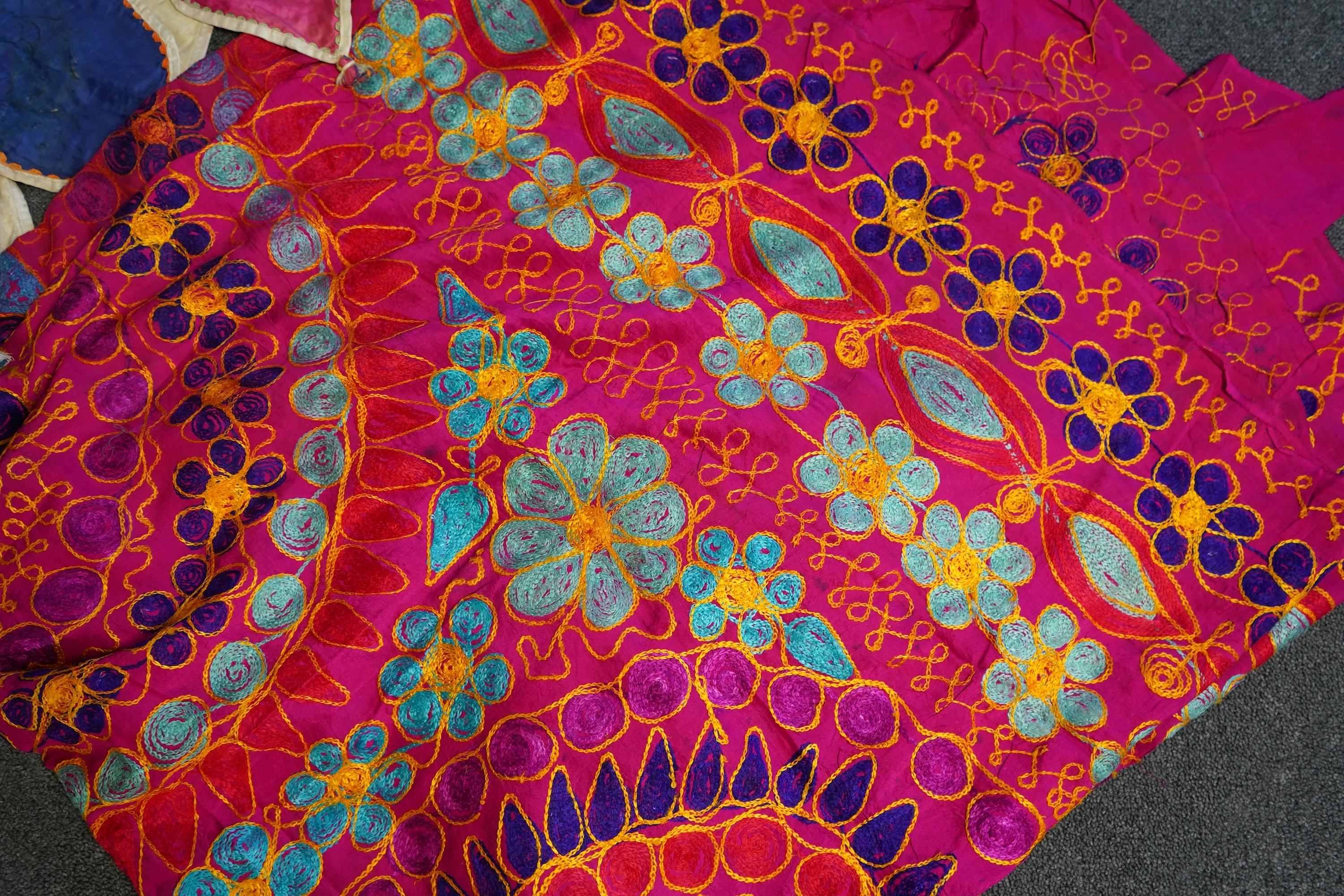 A large Indian silk embroidered and mirrored temple pelmet, with a cerise silk embroidered hanging and a length of cotton wax resist style printed fabric. Temple pelmet 468cm long x 70cm, deep. Condition - the pelmet has